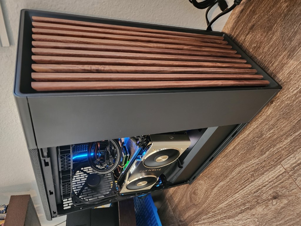 Dark grey PC case with a wooden-slat top vent and a horizontally mounted Titan RTX inside