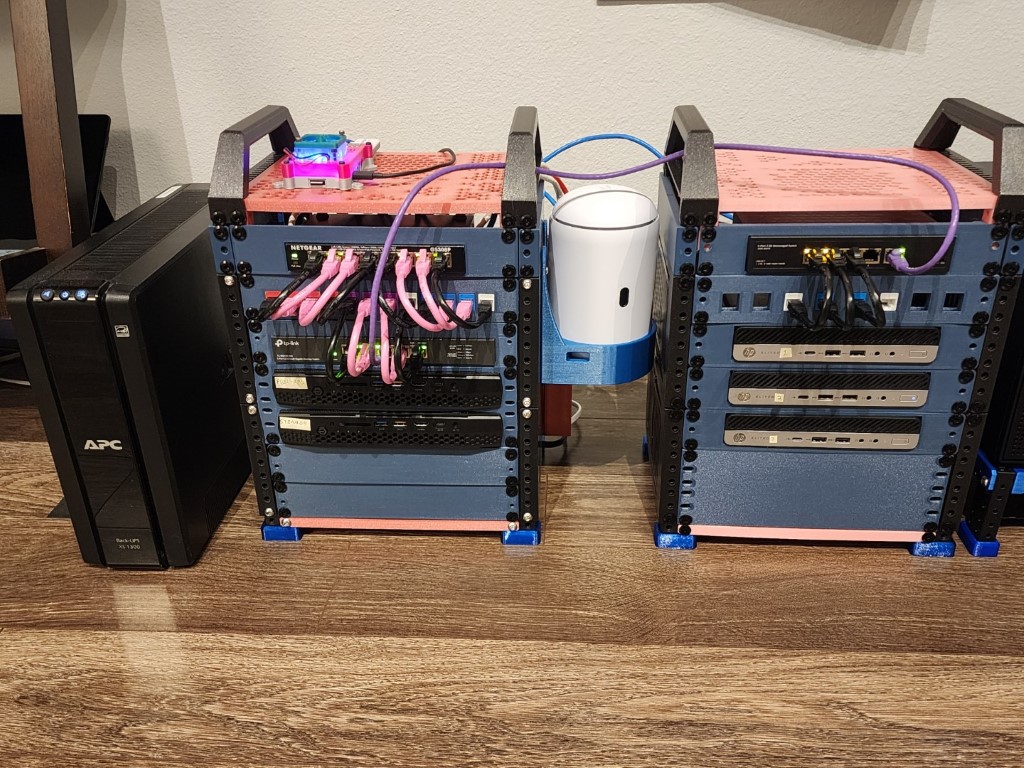 Home server setup with a UPS and two blue 3D-printed racks of switches and HP mini PCs