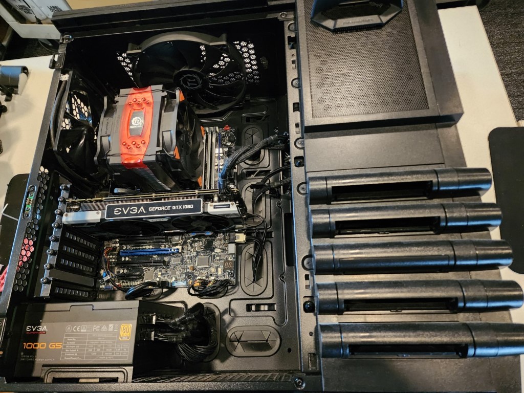 Interior close-up of a custom build showing an EVGA GTX 1080, orange-top CPU cooler, and EVGA 1000 G5 PSU